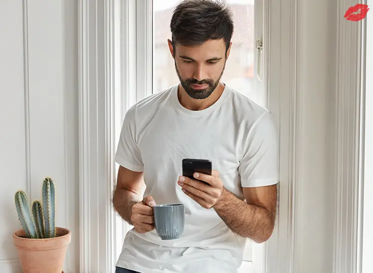 Hombre guapo con barba utiliza moderno dispositivo de teléfono inteligente